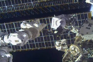 Spacewalking astronauts avoid debris as they repair antenna