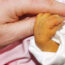 A newborn holding an adult's hand