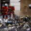 Firefighters controlling the remains of a rubbish fire from Thursday night's protests in Paris against the retirement Bill