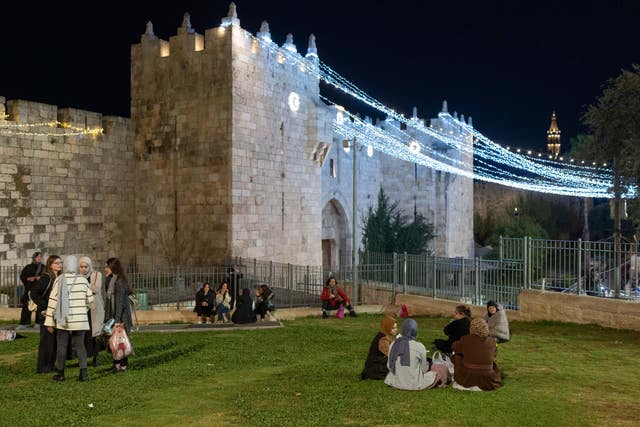 62759dc454e3485f9fc0c7ff1edd6995 Palestinians sit together next to Damascus Gate decorated with lights at the beginning of Ramadan, just outside Jerusalem’s Old City