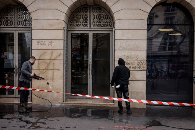 68fa7f23ae364e99b98b975e577106d0 Council workers clean the wall of graffiti daubed during protests