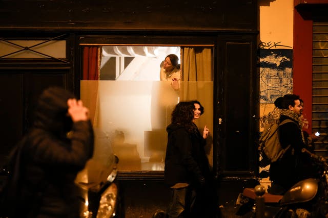 f24d692570e345ddb5a1f52e06ec046c A woman watches through a window as protesters march in Paris on Wednesday