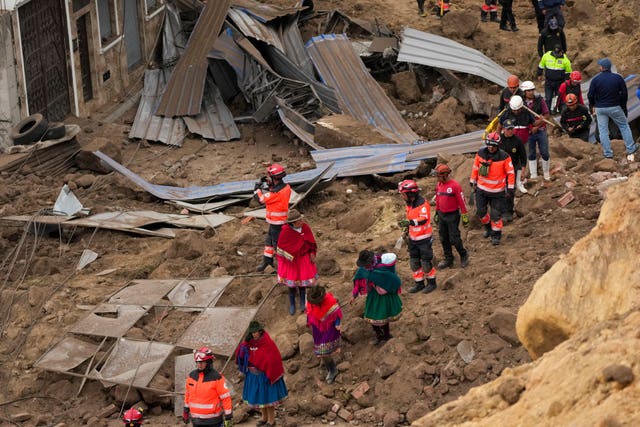 5dc906a4e5da4cae95f06cd242def0a4 Rescue workers and residents walk amid the debris (Dolores Ochoa/AP)