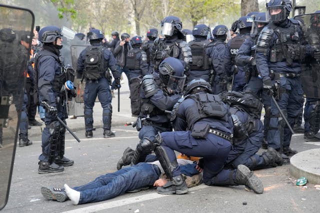 6092a50dbe9f4481bcea03ad3d64e793 A man lies on the pavement after riot police officers charged during a demonstration in Paris
