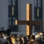 A cross stands above the crowd during a vigil held for victims of The Covenant School shooting on Wednesday, March 29, 2023, in Nashville, Tenn