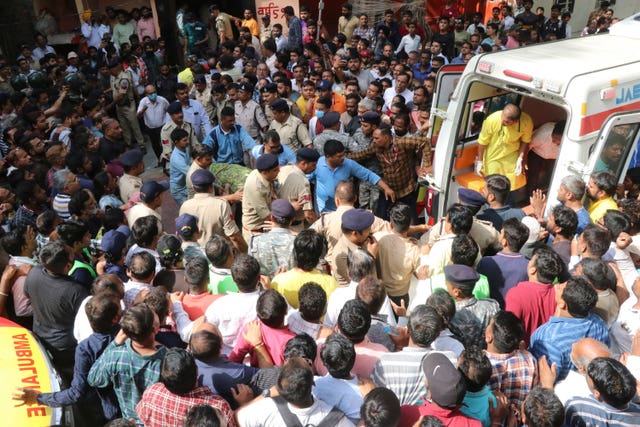 5c59f3eedfd044bc8b489fea5dd60b1e An accident victim is carried towards a waiting ambulance