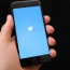 A person uses the Twitter app on an iPhone