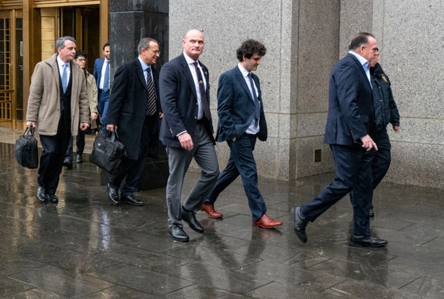 2-70437046 Cryptocurrency entrepreneur Sam Bankman-Fried, second from right, arrives for an appearance at Manhattan federal court in New York