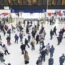 Commuters walk by departure boards at a train station