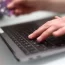 a woman using a laptop as she holds a bank card