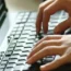 Hands typing on a computer keyboard
