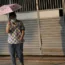 A woman holds an umbrella to shelter from the sun in Bangkok, Thailand