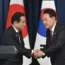 South Korean President Yoon Suk Yeol, right, shakes hands with Japanese Prime Minister Fumio Kishida