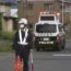 Police officers stand guard on a street leading to a building where a man was holed up in Nakano, central Japan