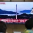 A TV screen shows an image of North Korea’s rocket launch
