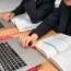 Students using textbooks and laptops