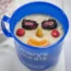 A Mary's Meals cup of porridge with fruit smiley face