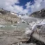 Chunks of ice float in a lake in front of the Rhone Glacier