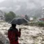 A man looks on to a swollen river