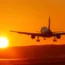 Plane takes off from a runway towards the sunset