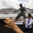 Fans gather in front of a statue of martial artist Bruce Lee to commemorate the 50th anniversary of his death