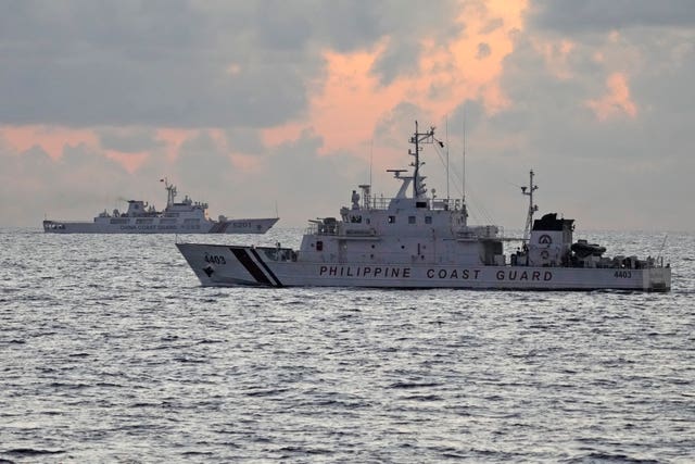 69beec39dbe94e248febdf1406781cc2 Philippine coastguard patrol vessel BRP Malapascua, right, passes by Chinese coastguard ship with bow number 5201 during sunrise near the Second Thomas Shoal