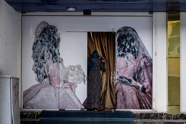 A woman enters a beauty salon in Kabul