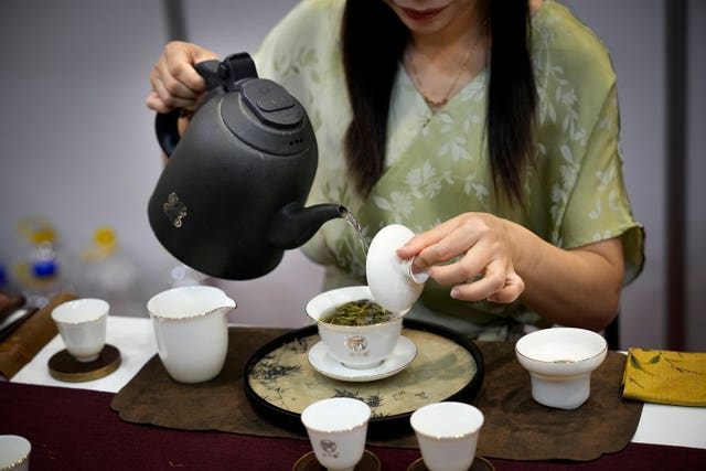 6fa1a97cbe9442d390dac1b0cda8c3cf A Chinese woman performs tea art