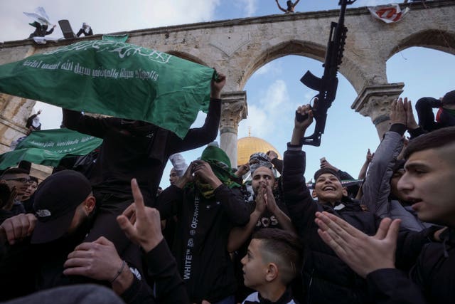 7bca962ad5b4498a9b9f7aa4764ac8c2 Palestinians brandish a toy gun and wave the flag of the Hamas militant group in protest against Israel during Eid celebrations by the Dome of the Rock shrine in the Al Aqsa Mosque compound in Jerusalem’s Old City