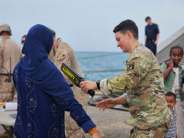 American nationals are searched by the US soldiers before boarding a ship in Port Sudan