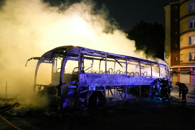a73b8b69586d4673a2853fdf346a5e6f Firefighters use a water hose on a burnt bus in Nanterre near Paris
