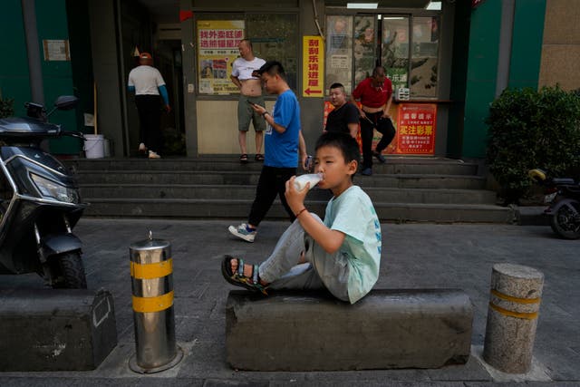 ac20558fc4e04044966852b456057fbc A boy drinks water on the street