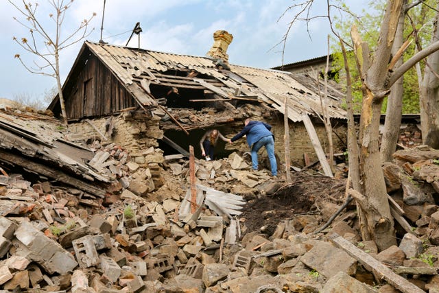 c582a674c4664c9c97b74f3a2b72f678 People help each other leave a damaged house after shelling that, according to Russian officials in Donetsk, was conducted by Ukrainian forces in the capital of Russian-controlled Donetsk region