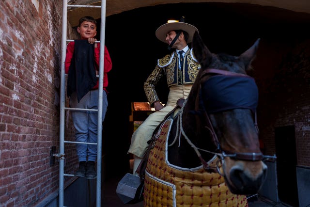 cc7f61722b7741e8b074c16fb01eb9bd A child watches a bullfight next to a picador, a horse mounted bullfighter assistant, at Las Ventas bullring in Madrid, Spain