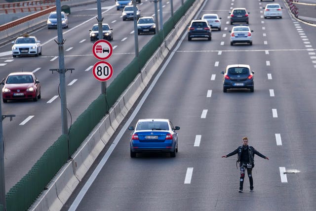ea8258c0bdca4b9aad684b07ce8e2103 A man attempts to block a motorway during a rally against violence in Belgrade, Serbia