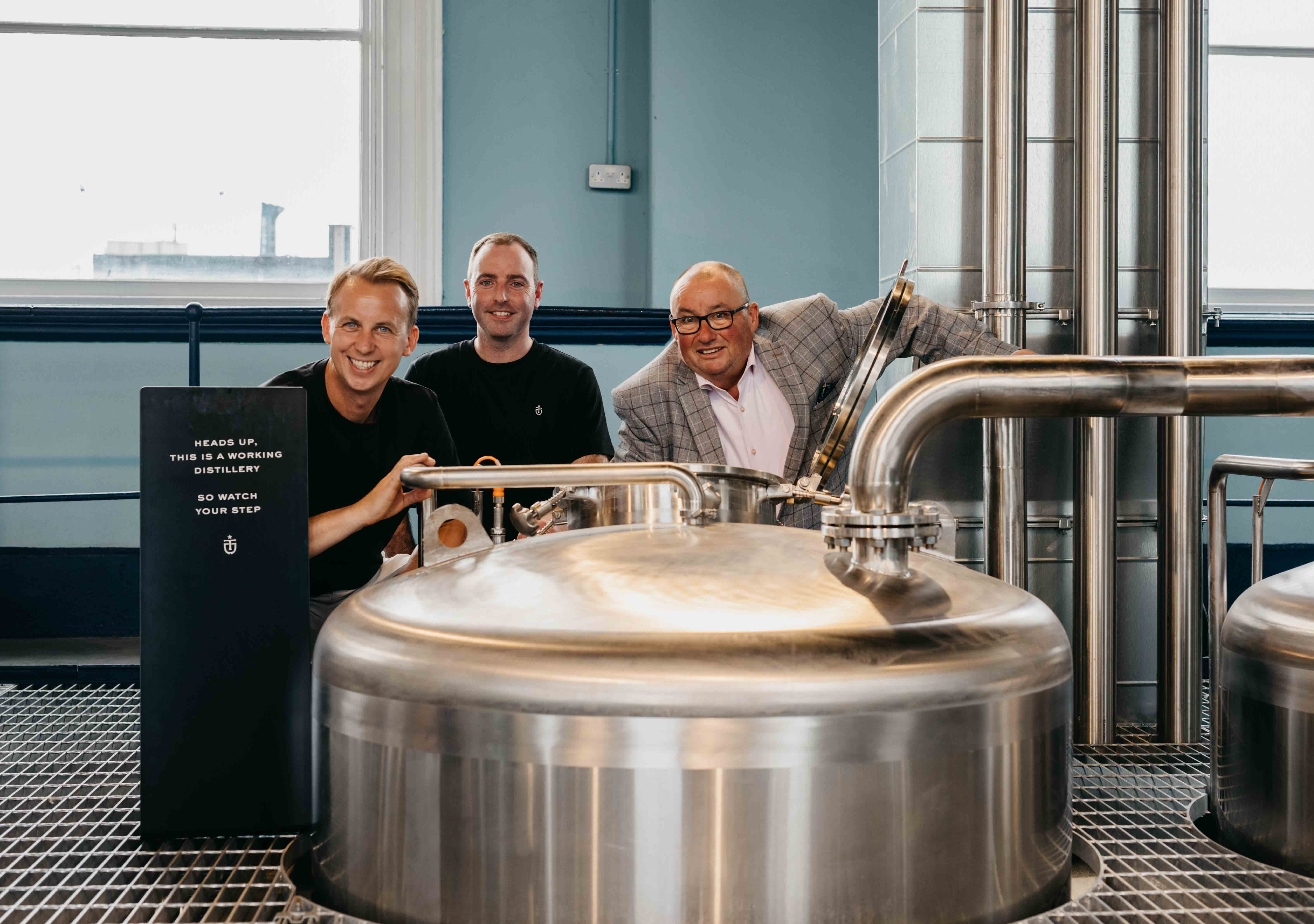 Titanic Distillers directors Stephen Symington (left) and Peter Lavery (right) joined Head Distiller Damien Rafferty to celebrate as production started at Belfast’s first working whiskey distillery since the days of prohibition in the 1930s. Titanic Distillers, located on the site of the historic Thompson Dock and Pumphouse in the heart of the city’s Titanic Quarter, was granted its Distillers License to produce spirits last week, and the shiny new copper stills are now up and firing at the distillery as whiskey production got under way in Belfast for the first time in almost 90 years.