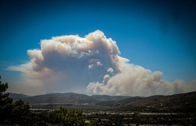 3d061ead61504e468b91f0a812bb1d0b-1 A cloud of smoke from a forest fire rises over the island of Rhodes