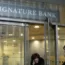 A woman leaves a branch of Signature Bank in New York, Monday, March 13, 2023