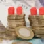 Monopoly houses on a stack of coins