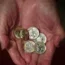 An elderly woman holding coins
