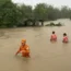 Rescuers wade through floodwater caused by Typhoon Doksuri in the northern Philippines