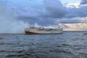 Crew member dies as fire on ship carrying 3,000 cars burns out of control