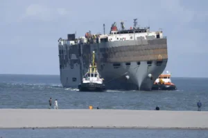 Car-carrying ship towed to Dutch port for salvaging after fire