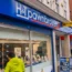 A woman looking in the window of an H&T Pawnbrokers shop