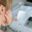 A woman uses a calculator to sum up expenses and holds her head worrying about the amount of money spent