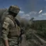 A Ukrainian soldier watches a Grad multiple launch rocket system firing shells near Bakhmut