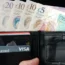 A wallet with pound notes and cards