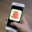 A general view of a woman holding a mobile phone with the Snapchat app