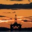 The sun rising behind an oil platform