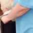 A carer pushing a woman in a wheelchair